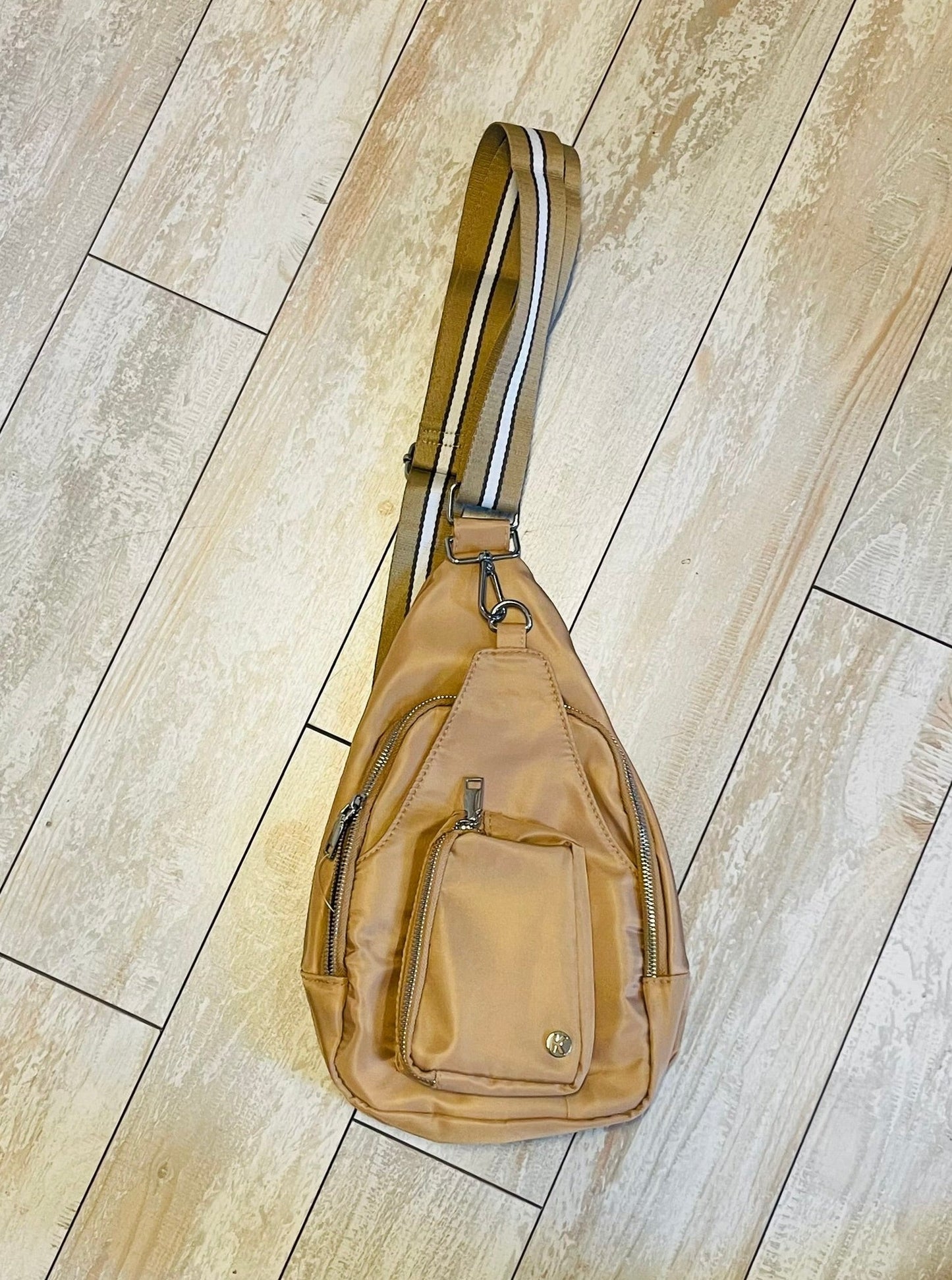 tan sling bag with striped strap